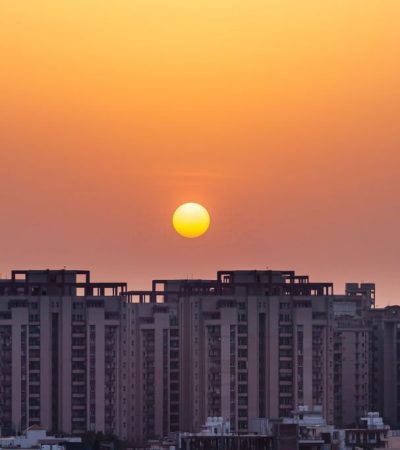 Residential apartment building and plot houses exterior view during sunset over an urban cityscape in the evening at Gurugram, Haryana, India.